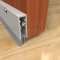 Clear Anodized Automatic Door Bottom Surface Applied to and Interior Wooden Door with Nylon Brush Seal in Lowered Position