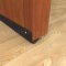 Pemko Dark Bronze Anodized Door Sweep #317N with Neoprene Bulb Seal Applied on Interior Wooden Door, Placed Beneath the Door